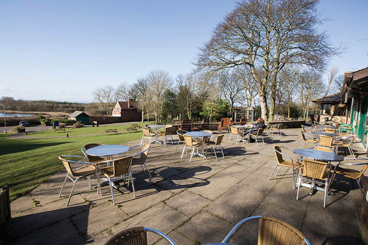 Outdoor seating on a patio looking over a park