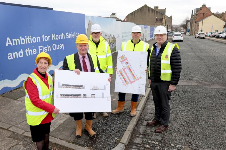 The Elected Mayor and Karbon Homes outside the Unicorn House site with blue billboards in the background