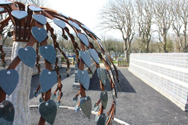 Metal tree with leaves which contain memorial messages for deceased family members