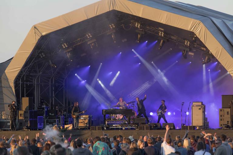 A colour photo of the stage at Mouth of Tyne festival with a crowd of people in the foreground
